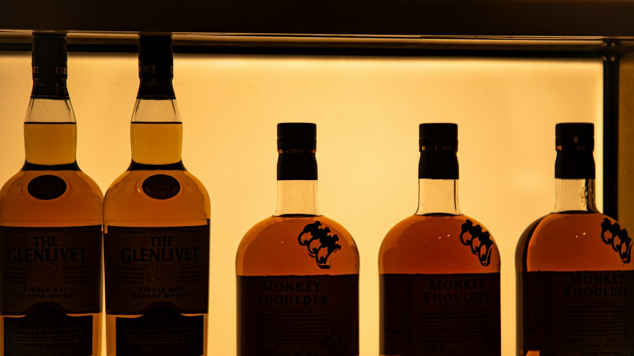 Bottles arranged on a lit retail shelf with warm display lighting